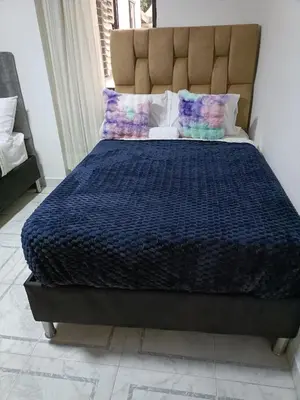 a bed with a blue comforter and pillows on it at cool de laureles Medellín in Medellín