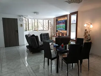 a living room with black chairs and a table at cool de laureles Medellín in Medellín
