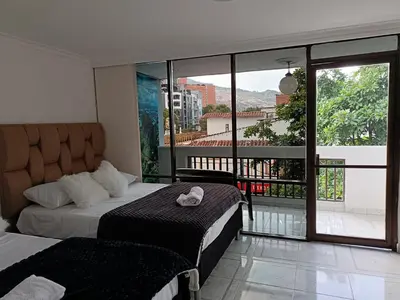 a bedroom with a bed and a balcony with a view at cool de laureles Medellín in Medellín