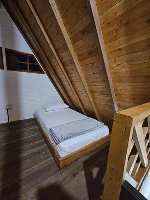 a bed in a room with a wooden ceiling at Chalet Los Sinsontes in San Rafael