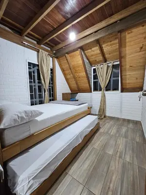 two beds in a room with wooden ceilings and wood floors at Chalet Los Sinsontes in San Rafael