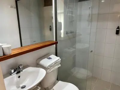 a bathroom with a shower and a toilet and a sink at Amoblados Medellin Poblado Patio Bonito in Medellín