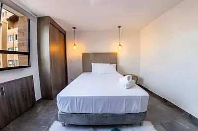 a bedroom with a large bed with white sheets at Vistas Top | Parking | Cerca De Estadio y 