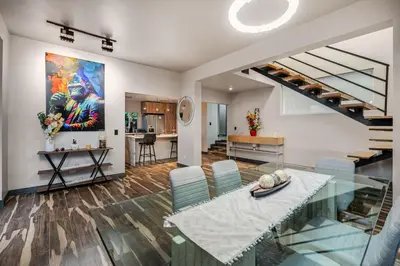 a dining room with a glass table and a staircase at Poblado Mansion With Hot Tub & A/C Sleeps 9 in Medellín