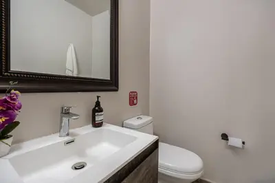 a bathroom with a sink and a toilet and a mirror at Poblado Mansion With Hot Tub & A/C Sleeps 9 in Medellín