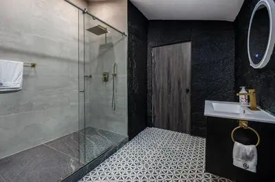 a bathroom with a glass shower and a sink at Poblado Mansion With Hot Tub & A/C Sleeps 9 in Medellín