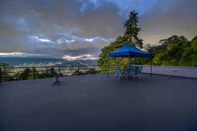 a patio with chairs and an umbrella on a balcony at Poblado Mansion With Hot Tub & A/C Sleeps 9 in Medellín