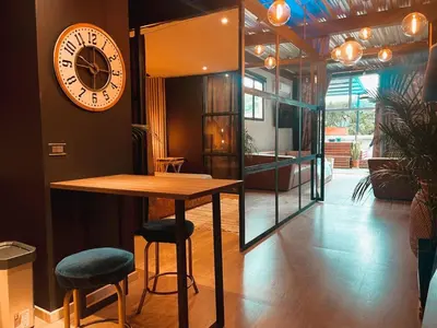 a clock on the wall next to a table and stools at PROVENZA LUXURY APARTMENTS TERRAZA in Medellín
