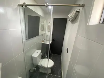 a white bathroom with a toilet and a shower at Springfield Ecoloft- Guatapé in Guatapé