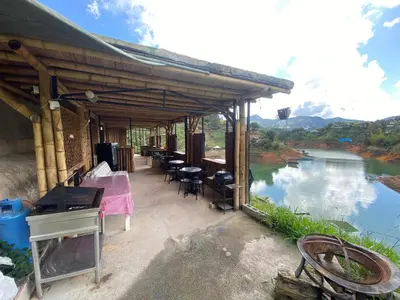 a house with a table and chairs and a river at Springfield Ecoloft- Guatapé in Guatapé