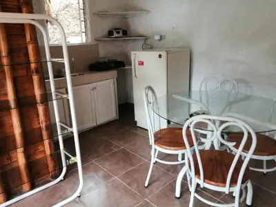 a kitchen with a table and chairs and a refrigerator at Cabaña rural con piscina in Manizales