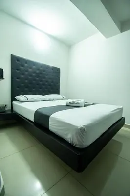 a bedroom with a large bed with a black headboard at Hotel Panorama Medellín in Medellín