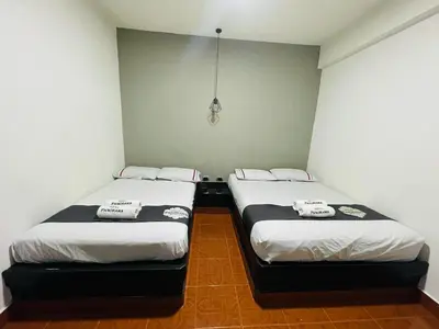 two twin beds in a small room withermottermottermott at Hotel Panorama Medellín in Medellín