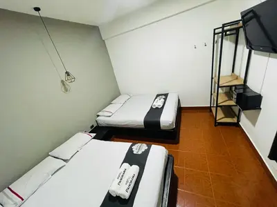 a small room with two beds and a television at Hotel Panorama Medellín in Medellín