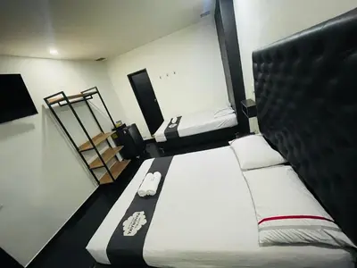 a small bedroom with two beds and a staircase at Hotel Panorama Medellín in Medellín