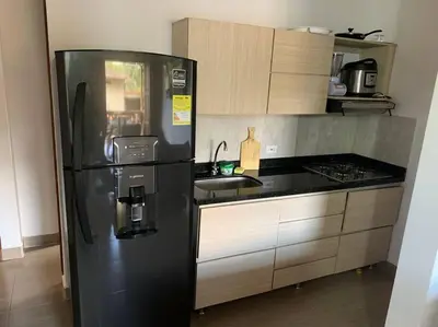 a kitchen with a black refrigerator and a sink at Apartamento Campestre 201 in Jardin