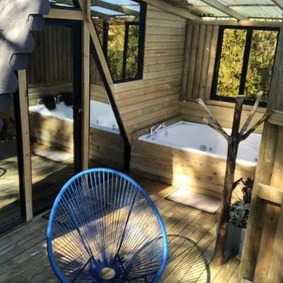 a bathroom with a tub and a blue chair at Rùstico Glamping in Santa Elena