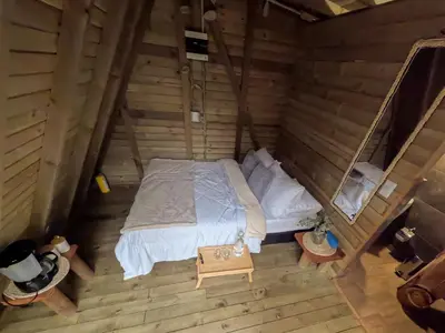 an overhead view of a bed in a log cabin at Rùstico Glamping in Santa Elena