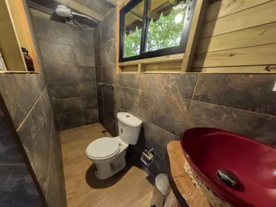 a bathroom with a toilet and a red sink at Rùstico Glamping in Santa Elena