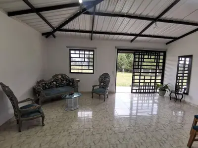 a living room with chairs and a table and windows at Hermosa finca a 5 minutos aeropuerto in Guarne
