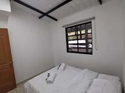 a white room with a bed and a window at Hermosa finca a 5 minutos aeropuerto in Guarne