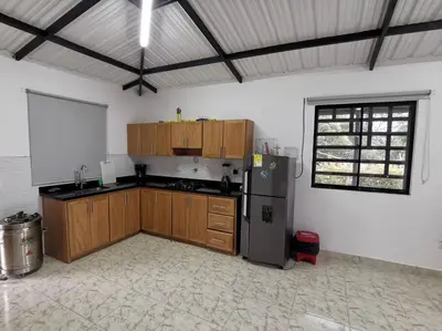 a kitchen with wooden cabinets and a refrigerator at Hermosa finca a 5 minutos aeropuerto in Guarne