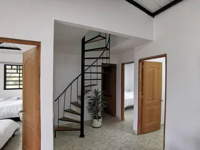 a room with a spiral staircase and a bedroom at Hermosa finca a 5 minutos aeropuerto in Guarne