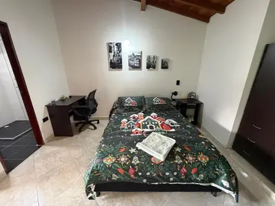 a bedroom with a bed with a green blanket at Amazing one bedroom apartment near the Airport ! in Rionegro