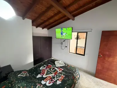 a bedroom with a bed with a tv on the wall at Amazing one bedroom apartment near the Airport ! in Rionegro