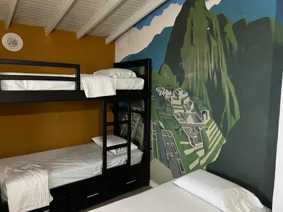 a bunk bed room with two bunk beds and a mural at The Wandering Paisa in Medellín