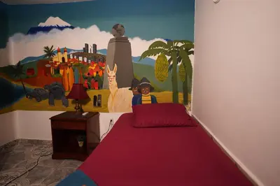 a bedroom with a painting on the wall and a bed at The Wandering Paisa in Medellín