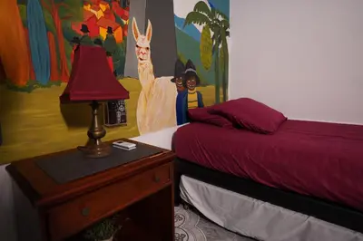 a bedroom with a bed and a table with a lamp at The Wandering Paisa in Medellín
