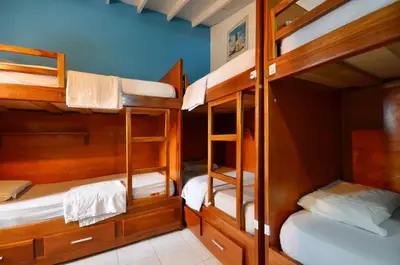 a room with three bunk beds in a house at The Wandering Paisa in Medellín