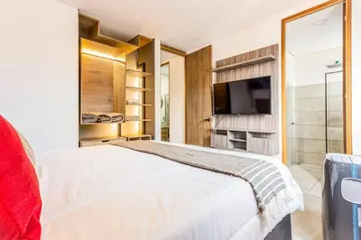 a bedroom with a white bed and a television at Apartamento Lujoso cerca del Estadio Piso 6to in Medellín