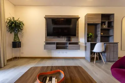 a living room with a flat screen tv on a wall at Apartamento Lujoso cerca del Estadio Piso 6to in Medellín