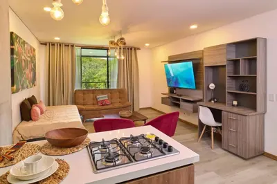 a kitchen and living room with a stove top oven at Apartamento Lujoso cerca del Estadio Piso 6to in Medellín