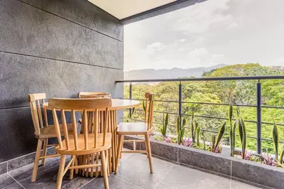 a table and chairs on a balcony with a view at Apartamento Lujoso cerca del Estadio Piso 6to in Medellín