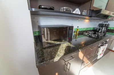 a kitchen with a black counter top with a microwave at Top floor apt w/Balcony in El Poblado in Medellín