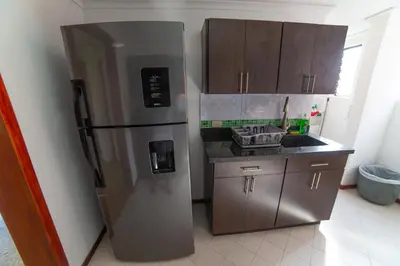 a kitchen with a stainless steel refrigerator and a sink at Top floor apt w/Balcony in El Poblado in Medellín