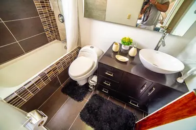 a bathroom with a toilet and a sink and a mirror at Top floor apt w/Balcony in El Poblado in Medellín