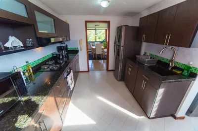 a kitchen with black counter tops and brown cabinets at Top floor apt w/Balcony in El Poblado in Medellín