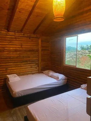 two beds in a wooden room with a window at El mirador de San Joaquin in San Luis