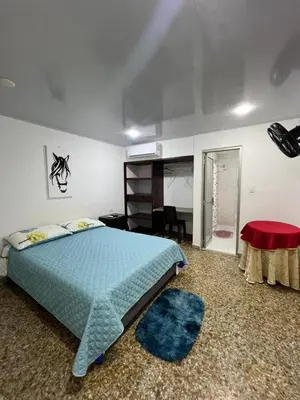 a bedroom with a blue bed and a red rug at HOTEL GANADERO in La Dorada