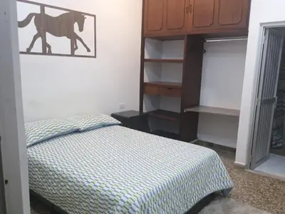 a bedroom with a bed with a picture of a camel on the wall at HOTEL GANADERO in La Dorada