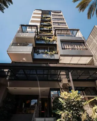 a tall building with balconies and plants on it at Sonata 44 Hotel Laureles in Medellín
