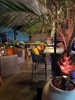 a restaurant with tables and chairs and a palm tree at Sonata 44 Hotel Laureles in Medellín