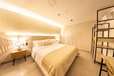 a bedroom with a large bed and a book shelf at Sonata 44 Hotel Laureles in Medellín