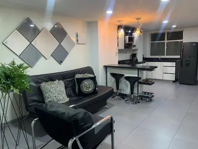 a living room with a couch and a kitchen at hermoso y nuevo apartamento en laureles in Medellín