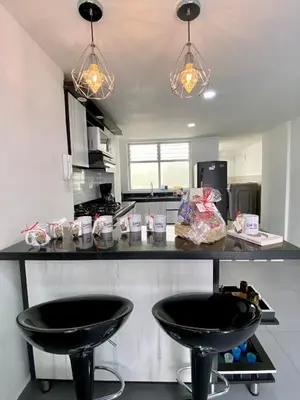 a kitchen with two black stools at a counter at hermoso y nuevo apartamento en laureles in Medellín