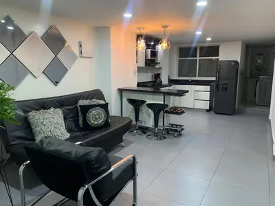 a living room with a couch and a kitchen at hermoso y nuevo apartamento en laureles in Medellín